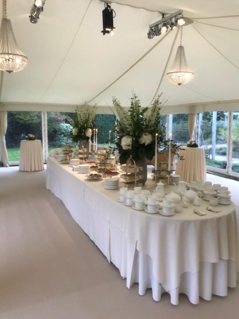 Buffet with white flowers in a marquee for a memorial reception