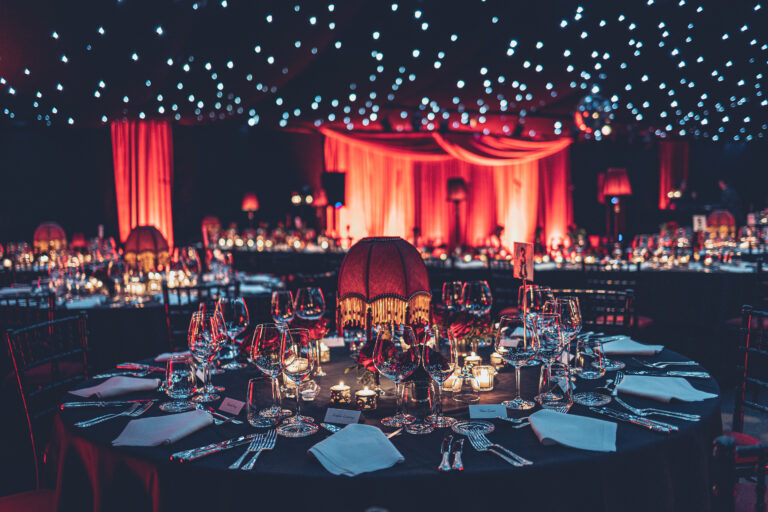 Themed dinner party with red lighting and fringed lampshades