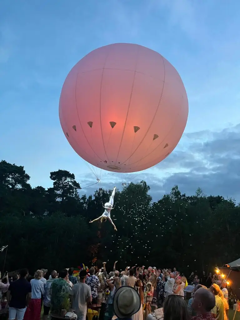 Giant balloon and aerial performer above a festival crowd